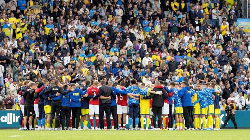 Para pemain dan staf Ukraina dan Denmark berkumpul setelah pertandingan dihentikan karena Christian Eriksen dari Denmark pingsan saat pertanidngan persahabatan di Stadion Stadion Odense, Denmark, Minggu (7/6/2026). (Bo Amstrup/Ritzau Scanpix via REUTERS)
