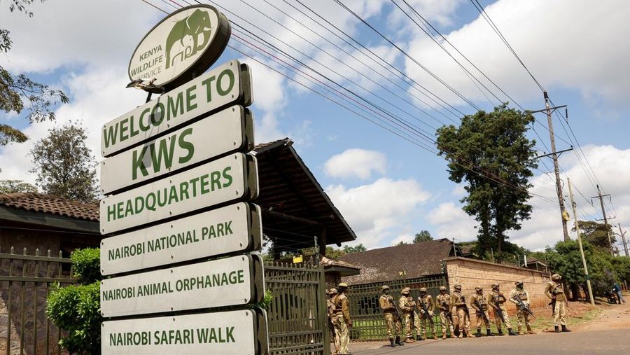 Para petugas Kenya Wildlife Service (KWS) menjaga pintu masuk Taman Nasional Nairobi sementara para aktivis lingkungan berpartisipasi dalam pawai menentang perampasan lahan taman dan rencana relokasi Panti Asuhan Hewan Nairobi di Nairobi, Kenya, 8 Juni 2026.