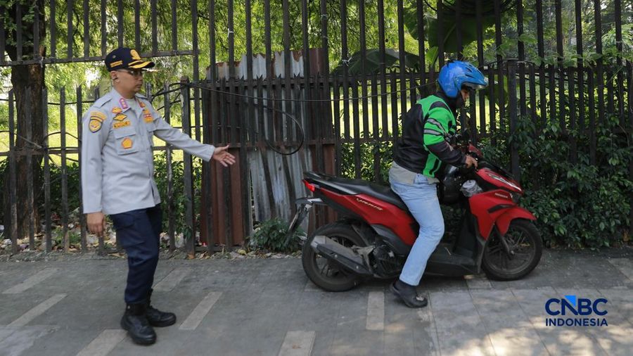 Petugas Dinas Perhubungan (Dishub) DKI Jakarta saat menilang mobil taksi yang parkir sembarangan di kawasan Dukuh Atas, Jakarta, Senin (8/6/2026). (CNBC Indonesia/Muhammad Sabki)