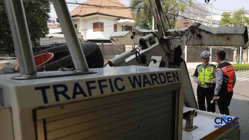 Petugas Dinas Perhubungan (Dishub) DKI Jakarta saat menilang mobil taksi yang parkir sembarangan di kawasan Dukuh Atas, Jakarta, Senin, (8/6/2026). (CNBC Indonesia/Muhammad Sabki)