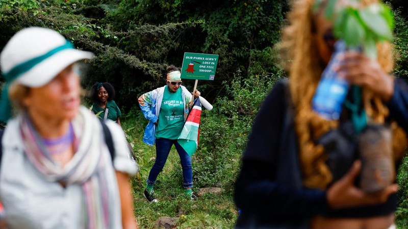 Seorang aktivis lingkungan berkumpul kembali setelah petugas polisi anti huru hara melemparkan tabung gas air mata karena berpartisipasi dalam pawai menentang pengerahan lahan Taman Nasional Nairobi dan rencana relokasi Panti Asuhan Hewan Nairobi di Nairobi, Kenya, 8 Juni 2026.