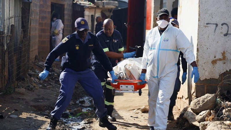 Anggota tim forensik membawa jenazah di lokasi kejadian setelah, menurut polisi, seorang pria bersenjata melepaskan tembakan di permukiman kumuh di Cleveland, Johannesburg, Afrika Selatan, 10 Juni 2026.