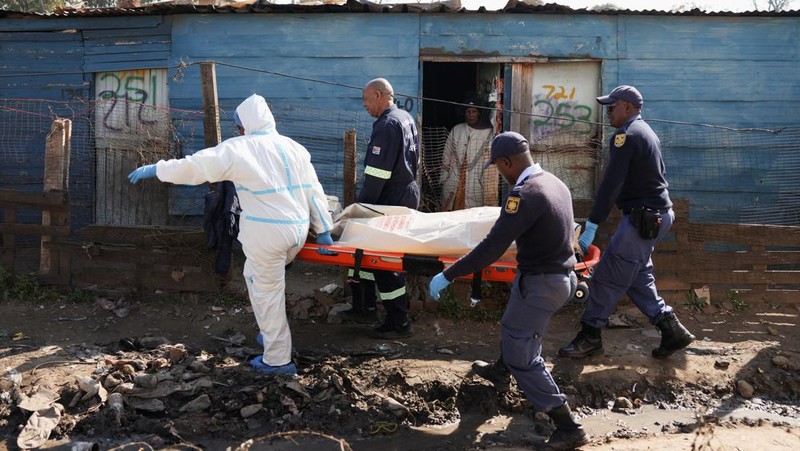 Anggota tim forensik membawa jenazah di lokasi kejadian setelah, menurut polisi, seorang pria bersenjata melepaskan tembakan di permukiman kumuh di Cleveland, Johannesburg, Afrika Selatan, 10 Juni 2026. (REUTERS/Siphiwe Sibeko)