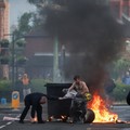 Api berkobar selama protes setelah serangan pisau pada 8 Juni yang menyebabkan seorang pria terluka parah dan mendorong polisi untuk menyatakan insiden kritis, di Newtownards Road di Belfast, Irlandia Utara, 9 Juni 2026. (REUTERS/Isabel Infantes)