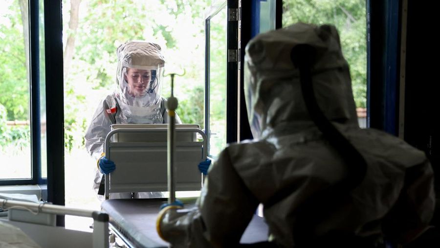 Para petugas kesehatan di klinik Virchow Berlin mengenakan perlengkapan pelindung lengkap saat institut tersebut memberikan tur melalui stasiun isolasi mereka untuk pasien Ebola di Berlin, Jerman, 9 Juni 2026.