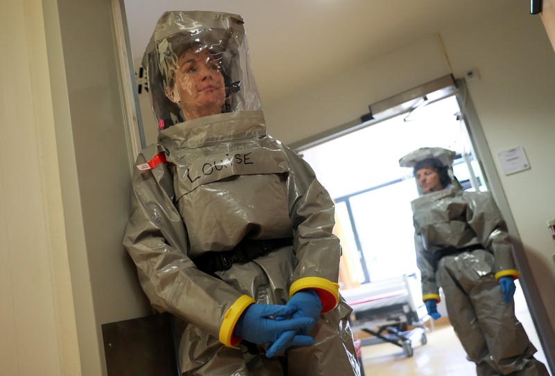 Para petugas kesehatan di klinik Virchow Berlin mengenakan perlengkapan pelindung lengkap saat institut tersebut memberikan tur melalui stasiun isolasi mereka untuk pasien Ebola di Berlin, Jerman, 9 Juni 2026. (REUTERS/Maryam Majd)