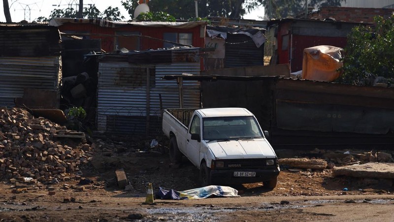 Sesosok mayat tergeletak tertutup di samping sebuah kendaraan setelah, menurut polisi, seorang pria bersenjata melepaskan tembakan di permukiman kumuh di Johannesburg, Afrika Selatan, 10 Juni 2026.
