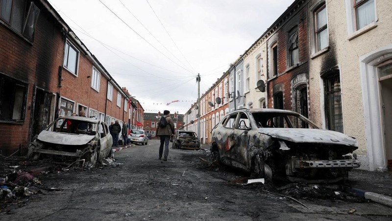 Warga memeriksa kerusakan di lingkungan mereka, setelah protes anti-imigran menyusul serangan pisau pada 8 Juni, yang menyebabkan seorang pria terluka parah dan mendorong polisi untuk menyatakan insiden kritis, di Lendrick Street, Belfast timur, Irlandia Utara, 10 Juni 2026.