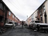 Warga memeriksa kerusakan di lingkungan mereka, setelah protes anti-imigran menyusul serangan pisau pada 8 Juni, yang menyebabkan seorang pria terluka parah dan mendorong polisi untuk menyatakan insiden kritis, di Lendrick Street, Belfast timur, Irla