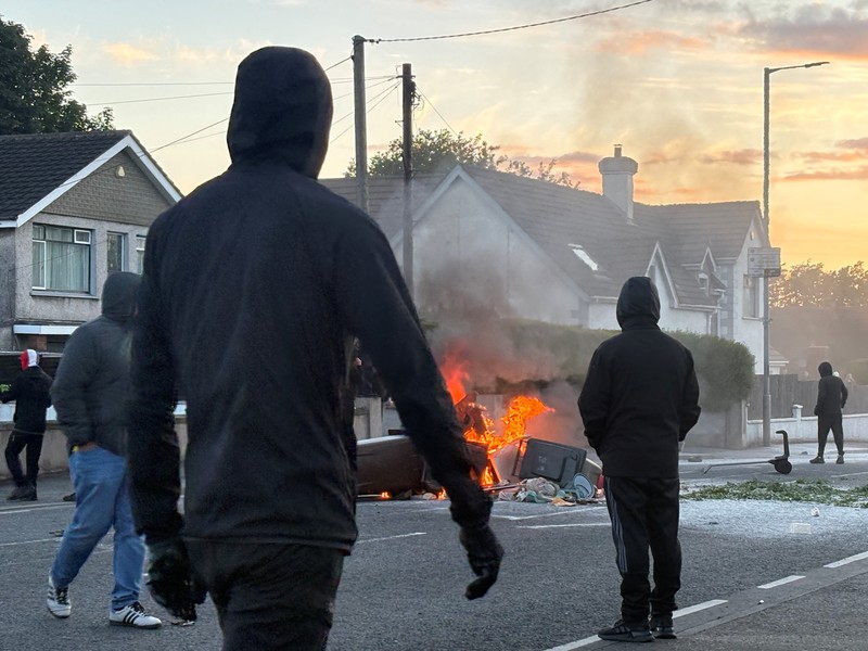 Sebuah kendaraan dibakar saat polisi memblokir sejumlah jalan di Belfast pada malam kedua kerusuhan bernuansa anti-imigran yang memicu ketegangan di wilayah tersebut. (Tangkapan Layar Video Reuters/)
