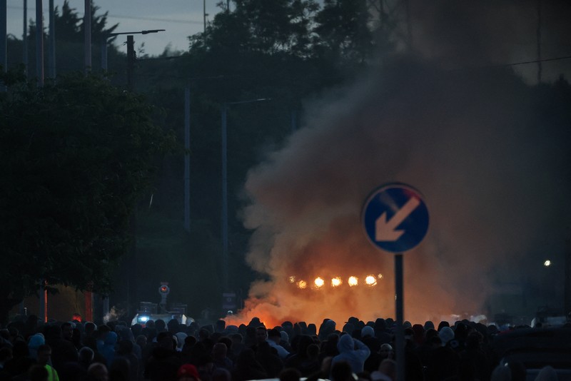 Sebuah kendaraan dibakar saat polisi memblokir sejumlah jalan di Belfast pada malam kedua kerusuhan bernuansa anti-imigran yang memicu ketegangan di wilayah tersebut. (Tangkapan Layar Video Reuters/)