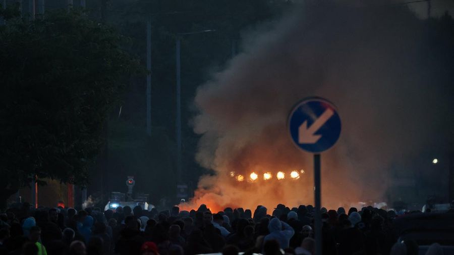 Asap mengepul saat para demonstran anti-imigran berunjuk rasa, menyusul serangan pisau pada 8 Juni yang menyebabkan seorang pria terluka parah dan mendorong polisi untuk menyatakan insiden tersebut sebagai insiden kritis, di Belfast, Irlandia Utara, 10 Juni 2026.
