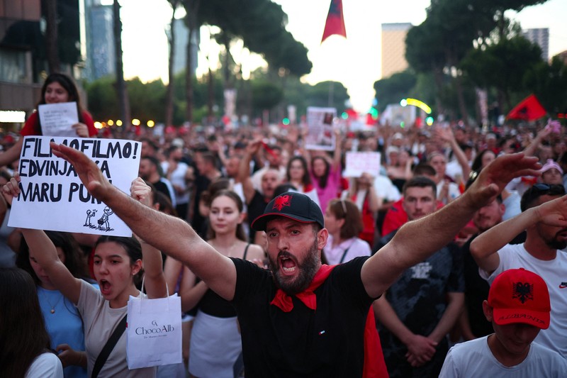 Pemandangan dari drone yang memperlihatkan para pengunjuk rasa mengibarkan bendera nasional Albania selama protes terhadap resor mewah, sebuah rencana dari perusahaan yang terkait dengan menantu Presiden AS Donald Trump, Jared Kushner, di bagian pesisir Adriatik yang sensitif terhadap lingkungan, di Tirana, Albania, 10 Juni 2026. (REUTERS/Florion Goga)