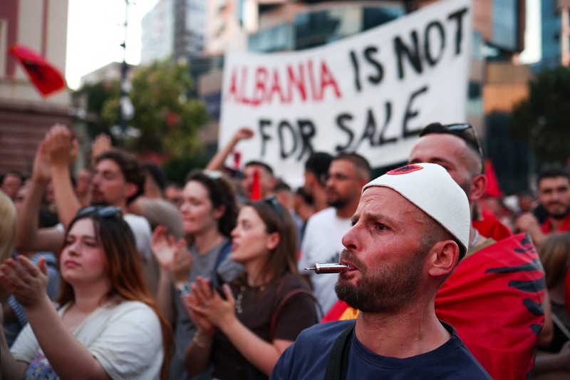 Pemandangan dari drone yang memperlihatkan para pengunjuk rasa mengibarkan bendera nasional Albania selama protes terhadap resor mewah, sebuah rencana dari perusahaan yang terkait dengan menantu Presiden AS Donald Trump, Jared Kushner, di bagian pesisir Adriatik yang sensitif terhadap lingkungan, di Tirana, Albania, 10 Juni 2026. (REUTERS/Florion Goga)