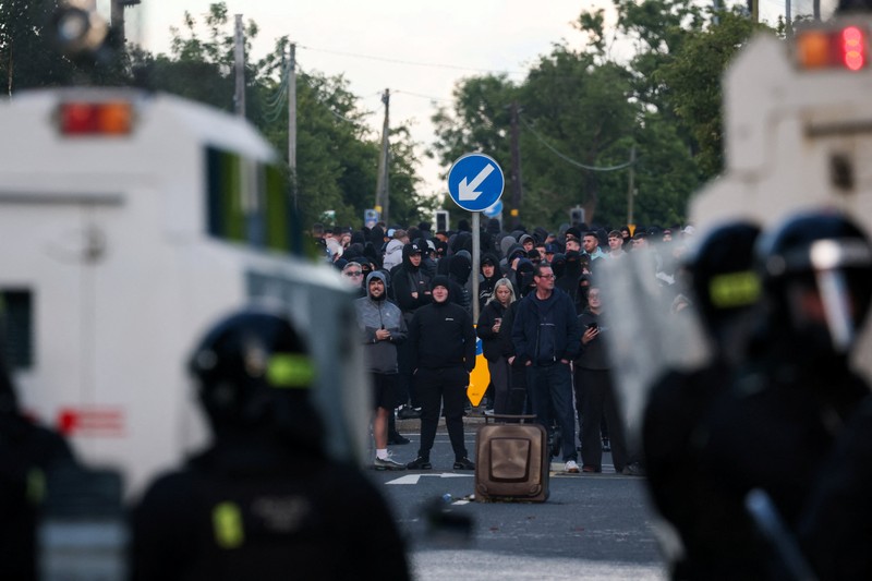 Sebuah kendaraan dibakar saat polisi memblokir sejumlah jalan di Belfast pada malam kedua kerusuhan bernuansa anti-imigran yang memicu ketegangan di wilayah tersebut. (Tangkapan Layar Video Reuters/)