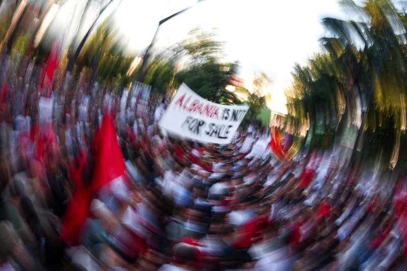 Pemandangan dari drone yang memperlihatkan para pengunjuk rasa mengibarkan bendera nasional Albania selama protes terhadap resor mewah, sebuah rencana dari perusahaan yang terkait dengan menantu Presiden AS Donald Trump, Jared Kushner, di bagian pesisir Adriatik yang sensitif terhadap lingkungan, di Tirana, Albania, 10 Juni 2026. (REUTERS/Florion Goga)