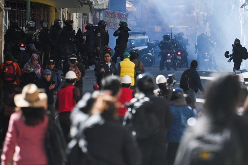 Para petugas polisi berjaga-jaga selama demonstrasi yang menyerukan pengunduran diri Presiden Bolivia Rodrigo Paz, menyusul protes dan blokade selama berminggu-minggu yang menyebabkan kekurangan makanan, bahan bakar, dan obat-obatan, di La Paz, Bolivia, 10 Juni 2026. (REUTERS/Claudia Morales)