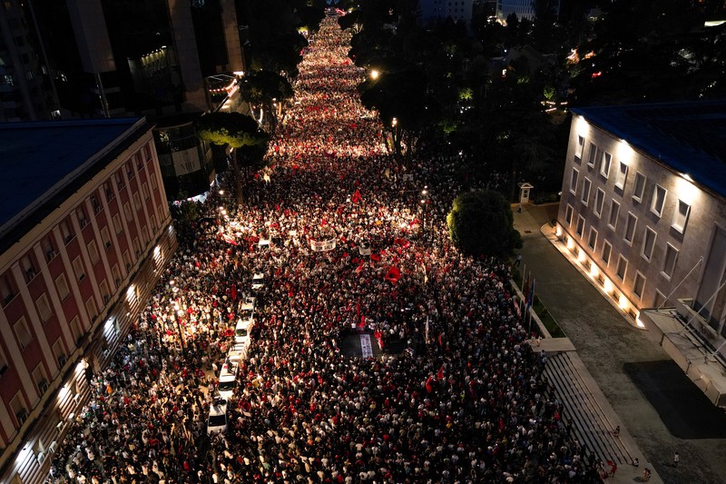 Pemandangan dari drone yang memperlihatkan para pengunjuk rasa mengibarkan bendera nasional Albania selama protes terhadap resor mewah, sebuah rencana dari perusahaan yang terkait dengan menantu Presiden AS Donald Trump, Jared Kushner, di bagian pesisir Adriatik yang sensitif terhadap lingkungan, di Tirana, Albania, 10 Juni 2026. (REUTERS/Florion Goga)