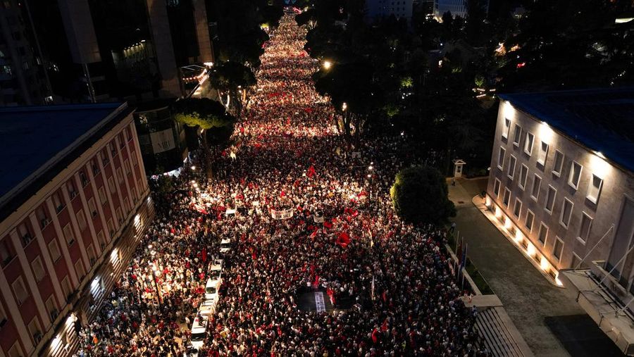 Pemandangan dari drone yang memperlihatkan para pengunjuk rasa mengibarkan bendera nasional Albania selama protes terhadap resor mewah, sebuah rencana dari perusahaan yang terkait dengan menantu Presiden AS Donald Trump, Jared Kushner, di bagian pesi