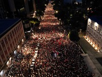 Pemandangan dari drone yang memperlihatkan para pengunjuk rasa mengibarkan bendera nasional Albania selama protes terhadap resor mewah, sebuah rencana dari perusahaan yang terkait dengan menantu Presiden AS Donald Trump, Jared Kushner, di bagian pesi