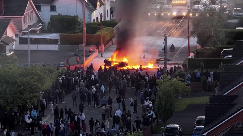 Sebuah kendaraan dibakar saat polisi memblokir sejumlah jalan di Belfast pada malam kedua kerusuhan bernuansa anti-imigran yang memicu ketegangan di wilayah tersebut. (Tangkapan Layar Video Reuters/)