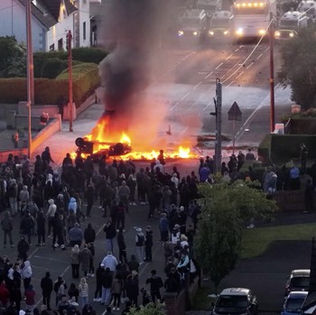 Sebuah kendaraan dibakar saat polisi memblokir sejumlah jalan di Belfast pada malam kedua kerusuhan bernuansa anti-imigran yang memicu ketegangan di wilayah tersebut. (Tangkapan Layar Video Reuters/)
