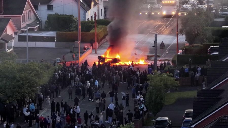 Sebuah kendaraan dibakar saat polisi memblokir sejumlah jalan di Belfast pada malam kedua kerusuhan bernuansa anti-imigran yang memicu ketegangan di wilayah tersebut. (Tangkapan Layar Video Reuters/)