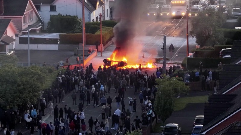 Sebuah kendaraan dibakar saat polisi memblokir sejumlah jalan di Belfast pada malam kedua kerusuhan bernuansa anti-imigran yang memicu ketegangan di wilayah tersebut. (Tangkapan Layar Video Reuters/)