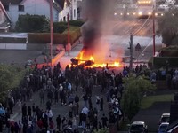Sebuah kendaraan dibakar saat polisi memblokir sejumlah jalan di Belfast pada malam kedua kerusuhan bernuansa anti-imigran yang memicu ketegangan di wilayah tersebut. (Tangkapan Layar Video Reuters/)