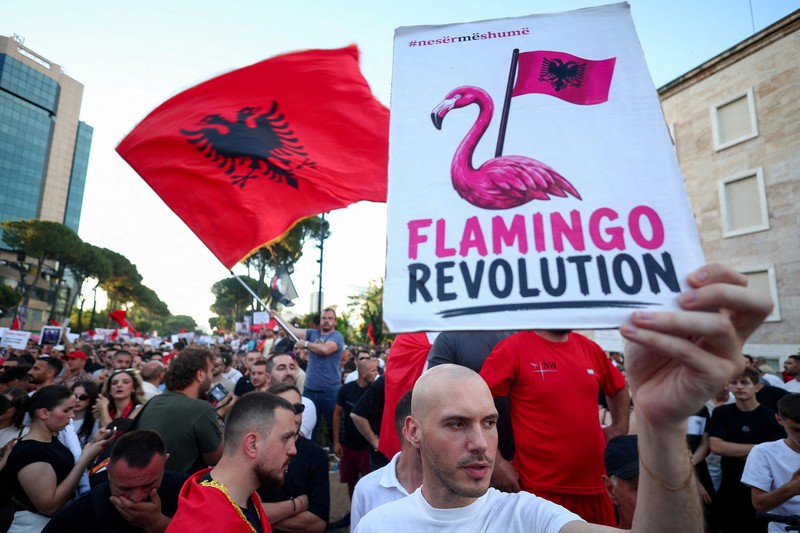 Pemandangan dari drone yang memperlihatkan para pengunjuk rasa mengibarkan bendera nasional Albania selama protes terhadap resor mewah, sebuah rencana dari perusahaan yang terkait dengan menantu Presiden AS Donald Trump, Jared Kushner, di bagian pesisir Adriatik yang sensitif terhadap lingkungan, di Tirana, Albania, 10 Juni 2026. (REUTERS/Florion Goga)