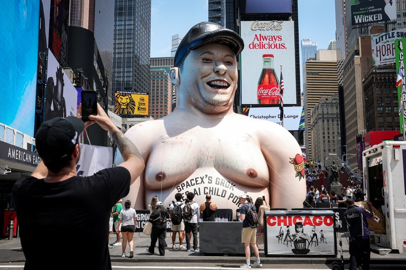 Sebuah karikatur tiup raksasa Elon Musk berdiri di Times Square mengkritik Grok, chatbot kecerdasan buatan yang dikembangkan oleh xAI, di Kota New York, New York, AS, 11 Juni 2026. (REUTERS/Roselle Chen)