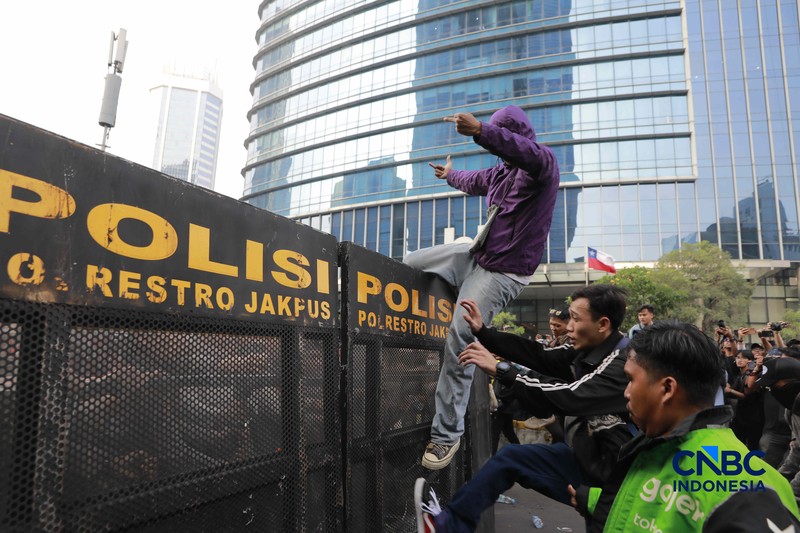 Sekelompok massa aksi saat mendorong besi pembatas saat aksi di Dukuh Atas, Sudirman, Jakarta, Jumat (12/6/2026). (CNBC Indonesia/Muhammad Sabki)