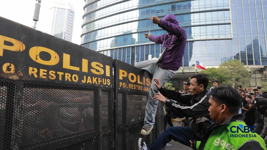 Sekelompok massa aksi saat mendorong besi pembatas saat aksi di Dukuh Atas, Sudirman, Jakarta, Jumat (12/6/2026). (CNBC Indonesia/Muhammad Sabki)
