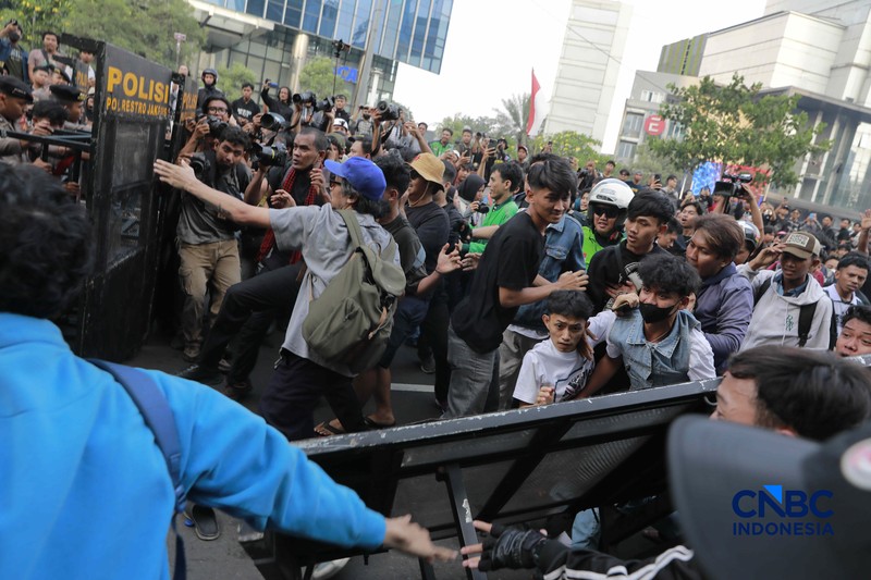 Sekelompok massa aksi saat mendorong besi pembatas saat aksi di Dukuh Atas, Sudirman, Jakarta, Jumat (12/6/2026). (CNBC Indonesia/Muhammad Sabki)