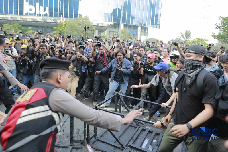 Sekelompok massa aksi saat mendorong besi pembatas saat aksi di Dukuh Atas, Sudirman, Jakarta, Jumat (12/6/2026). (CNBC Indonesia/Muhammad Sabki)