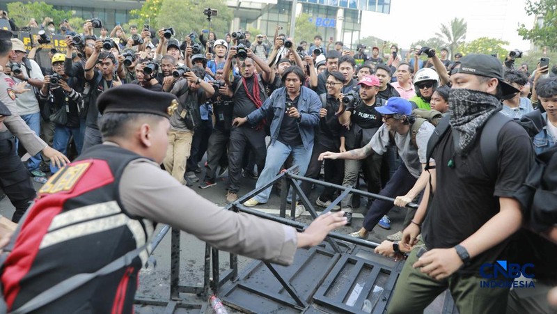 Sekelompok massa aksi saat mendorong besi pembatas saat aksi di Dukuh Atas, Sudirman, Jakarta, Jumat (12/6/2026). (CNBC Indonesia/Muhammad Sabki)