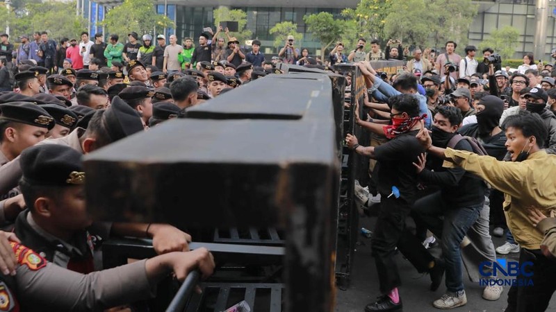 Sekelompok massa aksi saat mendorong besi pembatas saat aksi di Dukuh Atas, Sudirman, Jakarta, Jumat (12/6/2026). (CNBC Indonesia/Muhammad Sabki)