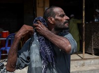 Allah Bux, 30 tahun, seorang buruh, menyeka keringat dengan syalnya setelah menurunkan barang dagangan di luar sebuah kafe pada hari musim panas yang terik di Karachi, Pakistan. 11 Juni 2026. (REUTERS/Akhtar Soomro)
