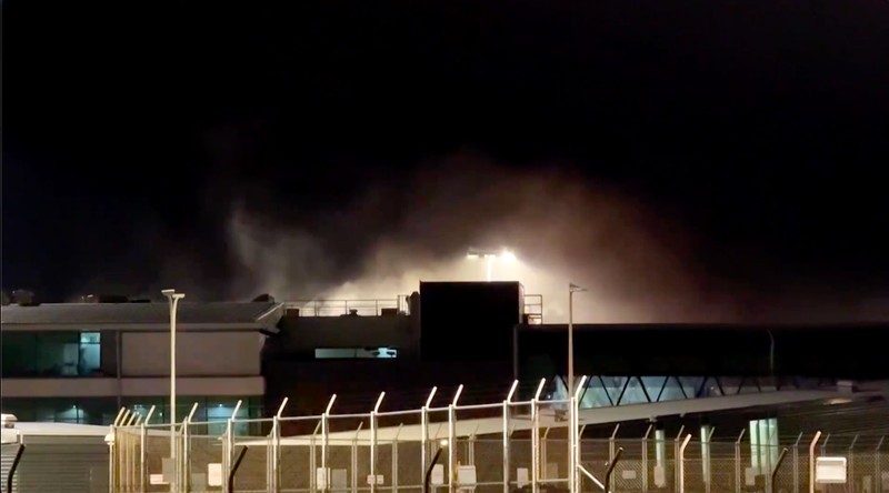 Kebakaran terjadi di Bandara Wellington, Selandia Baru, pada Jumat (12/6/2026) malam waktu setempat, yang memaksa evakuasi terminal utama dan menyebabkan sejumlah penerbangan dialihkan sebelum api berhasil dipadamkan. (Tangkapan Layar Video Reuters/)