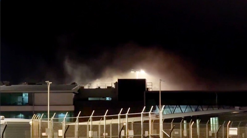 Kebakaran terjadi di Bandara Wellington, Selandia Baru, pada Jumat (12/6/2026) malam waktu setempat, yang memaksa evakuasi terminal utama dan menyebabkan sejumlah penerbangan dialihkan sebelum api berhasil dipadamkan. (Tangkapan Layar Video Reuters/)