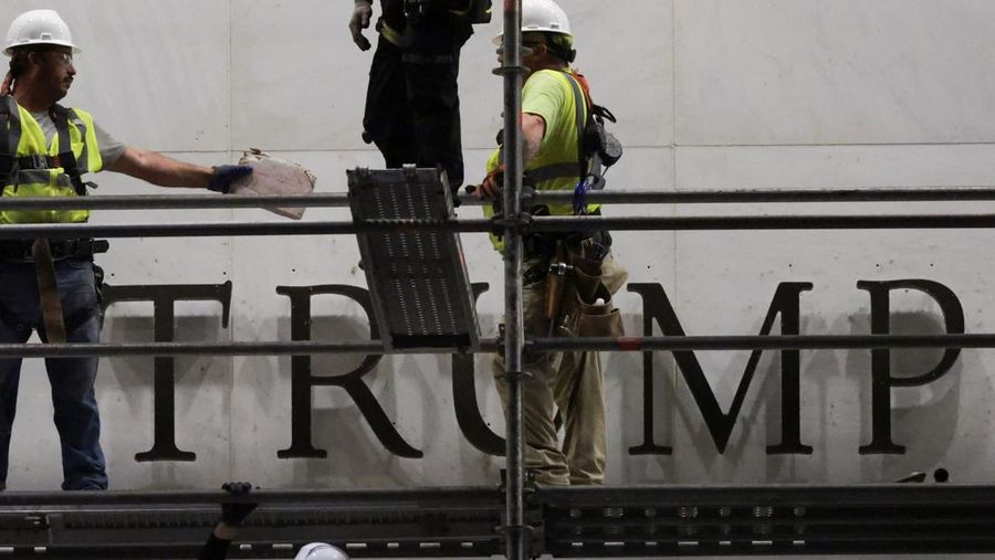 Para pekerja menyiapkan perancah sebelum melepas tulisan dari fasad John F. Kennedy Memorial Center for the Performing Arts, menyusul perintah hakim federal untuk menghapus nama Presiden AS Donald Trump dari institusi tersebut, di Washington, D.C., AS, 13 Juni 2026.
