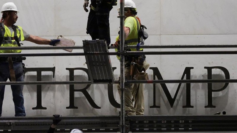 Para pekerja menyiapkan perancah sebelum melepas tulisan dari fasad John F. Kennedy Memorial Center for the Performing Arts, menyusul perintah hakim federal untuk menghapus nama Presiden AS Donald Trump dari institusi tersebut, di Washington, D.C., AS, 13 Juni 2026.