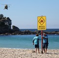 Para petugas penjaga pantai memasang tanda bertuliskan "Pantai Ditutup" setelah serangan hiu di Pantai Coogee di Sydney, Australia, 13 Juni 2026. (REUTERS/Hollie Adams)