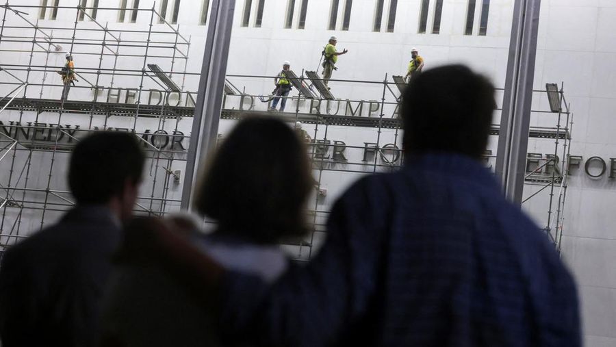 People look at workers on scaffolding preparing ahead of removing lettering from the facade of the John F. Kennedy Memorial Center for the Performing Arts, following a federal judge’s order to remove U.S. President Donald Trump's name from the institution, in Washington, D.C., U.S., June 13, 2026.