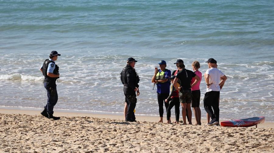Polisi berbicara dengan orang-orang di lokasi serangan hiu di Pantai Coogee di Sydney, Australia, 13 Juni 2026.