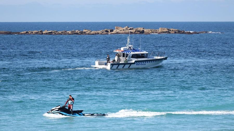 Seorang petugas penyelamat pantai dan sebuah perahu polisi NSW berpatroli di Pantai Coogee setelah serangan hiu di Sydney, Australia, 13 Juni 2026.