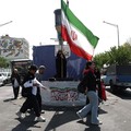 Seorang wanita memegang bendera Iran di jalanan Teheran, Iran, 10 Juni 2026. (Majid Asgaripour/WANA (West Asia News Agency) via REUTERS)