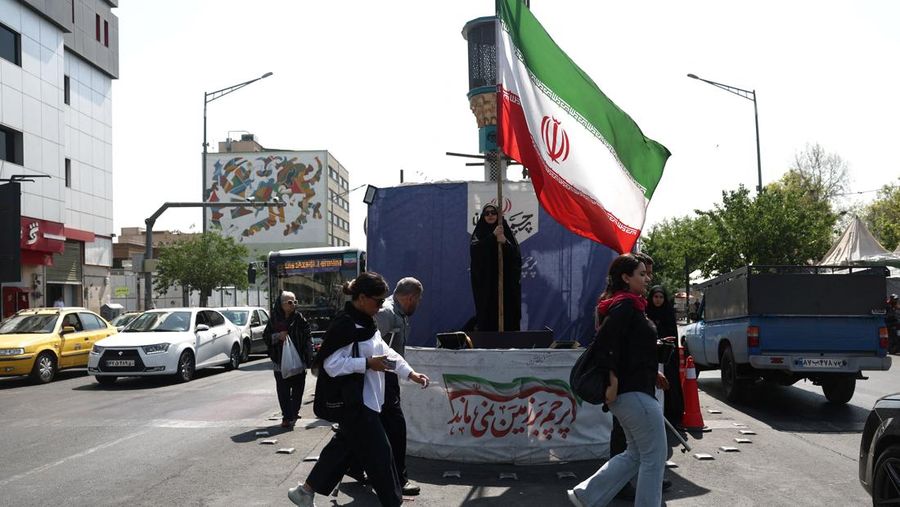Seorang wanita memegang bendera Iran di jalanan Teheran, Iran, 10 Juni 2026. (Majid Asgaripour/WANA (West Asia News Agency) via REUTERS)