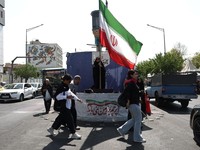 Seorang wanita memegang bendera Iran di jalanan Teheran, Iran, 10 Juni 2026. (Majid Asgaripour/WANA (West Asia News Agency) via REUTERS)