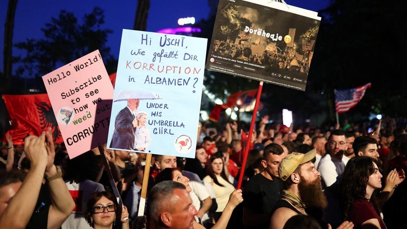 Para pengunjuk rasa memegang plakat selama protes terhadap resor mewah, sebuah rencana oleh perusahaan yang terkait dengan menantu Donald Trump, Jared Kushner, di bagian pesisir Adriatik yang sensitif terhadap lingkungan, di Tirana, Albania, 13 Juni 2026.